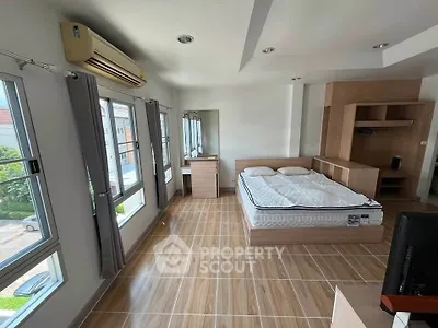 Spacious bedroom with modern furnishings and large windows offering natural light.