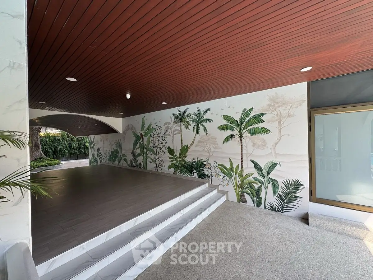 Elegant entrance with tropical mural and wooden ceiling in modern property