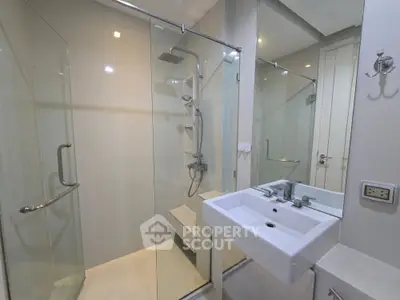 Modern bathroom with glass shower enclosure and sleek sink design