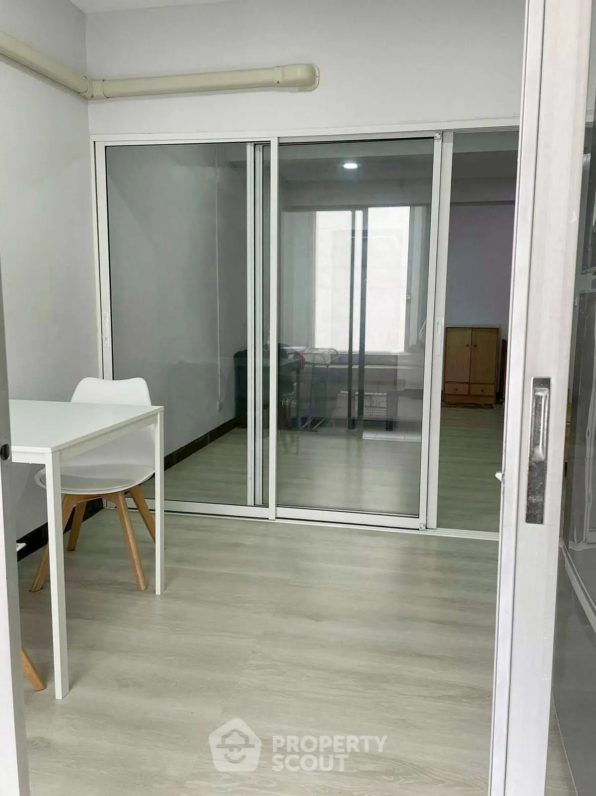 Modern study room with glass sliding doors and minimalist furniture design.