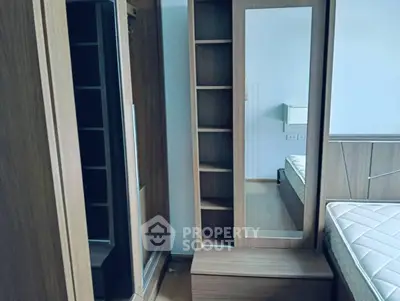 Modern bedroom with wooden wardrobe and mirror, showcasing sleek design and ample storage space.