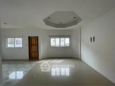 Spacious unfurnished living room with large windows and modern ceiling design