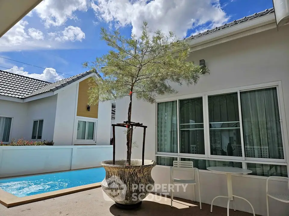 Charming residential exterior with private pool and modern patio area under a clear blue sky.