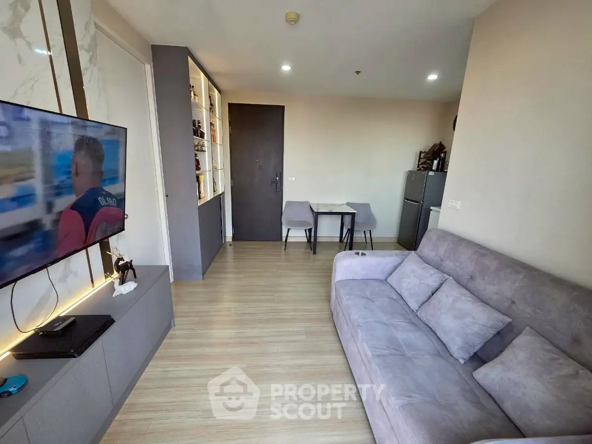 Modern living room with sleek design, featuring a cozy sofa, wall-mounted TV, and stylish shelving unit.
