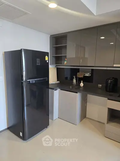 Modern kitchen with sleek black fridge and minimalist cabinetry
