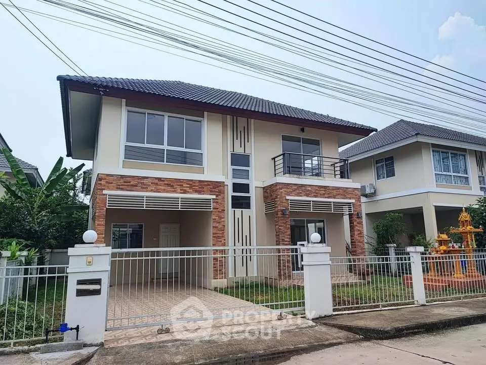 Modern two-story house with brick accents and gated front yard in suburban neighborhood.