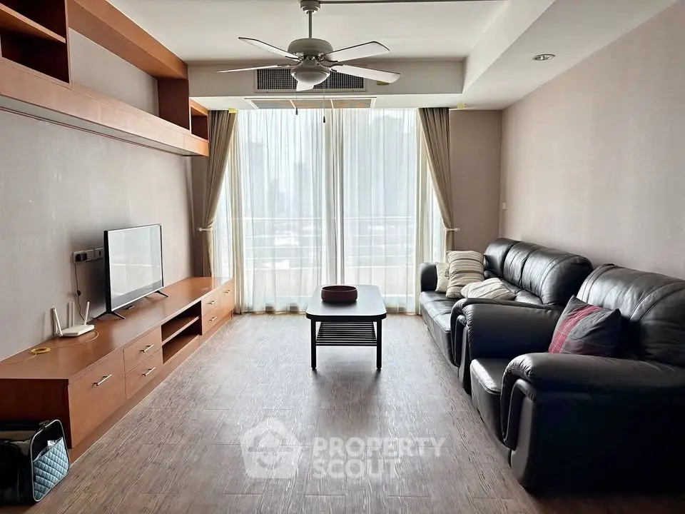 Spacious living room with modern furnishings and large windows offering natural light.