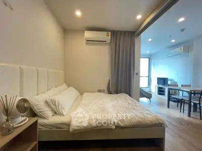 Modern studio apartment with cozy bedroom and open living area, featuring sleek furniture and ambient lighting.