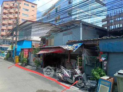 Street view of mixed-use buildings with scooters parked outside, showcasing urban living.