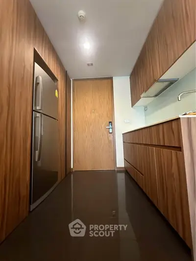 Modern kitchen with sleek wooden cabinetry and stainless steel fridge