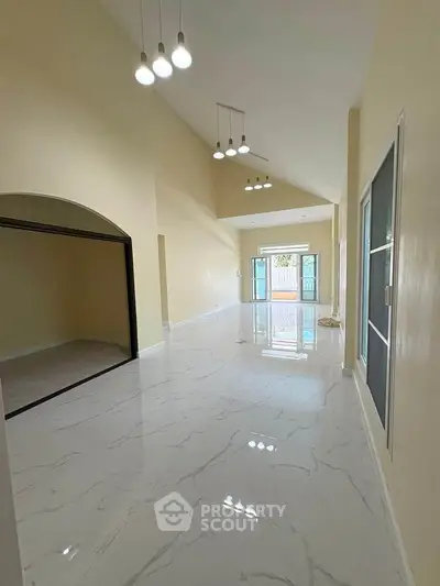 Spacious modern living room with high ceilings and elegant lighting in a luxury home.