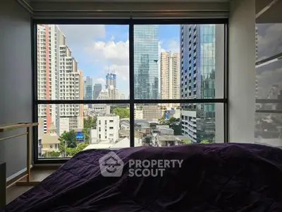 Stunning urban view from a modern bedroom window in a high-rise apartment.