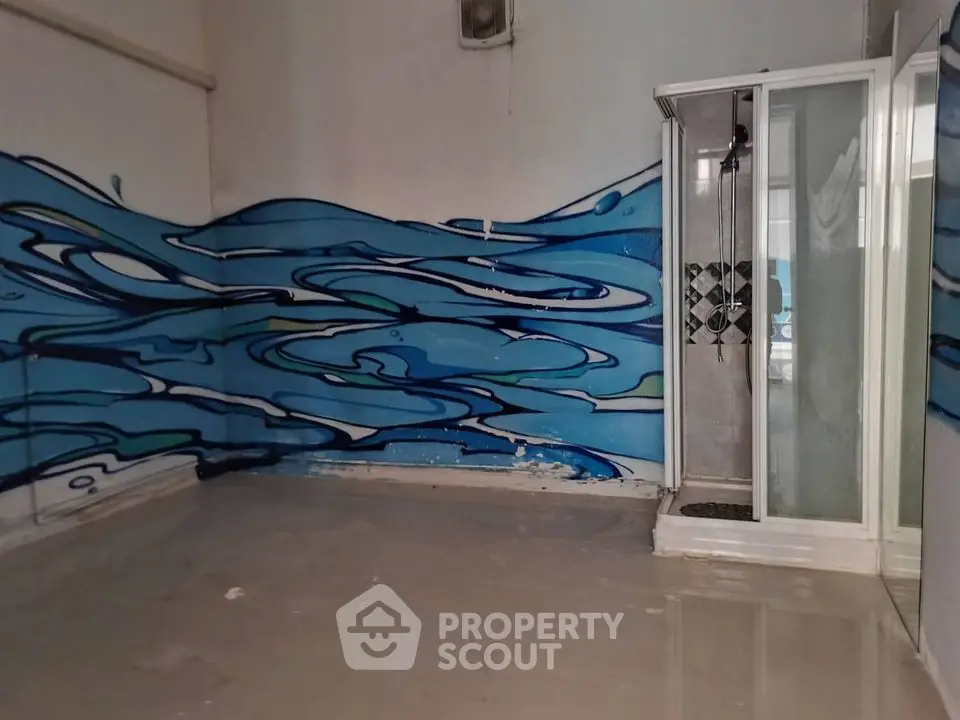 Unique bathroom with artistic wall mural and modern shower enclosure