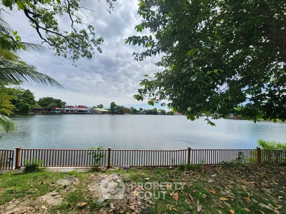 Scenic waterfront view with lush greenery and serene lake, perfect for tranquil living.