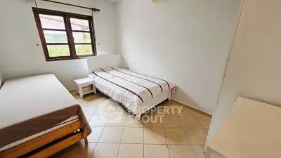 Cozy bedroom with twin beds and natural light, perfect for a peaceful retreat.