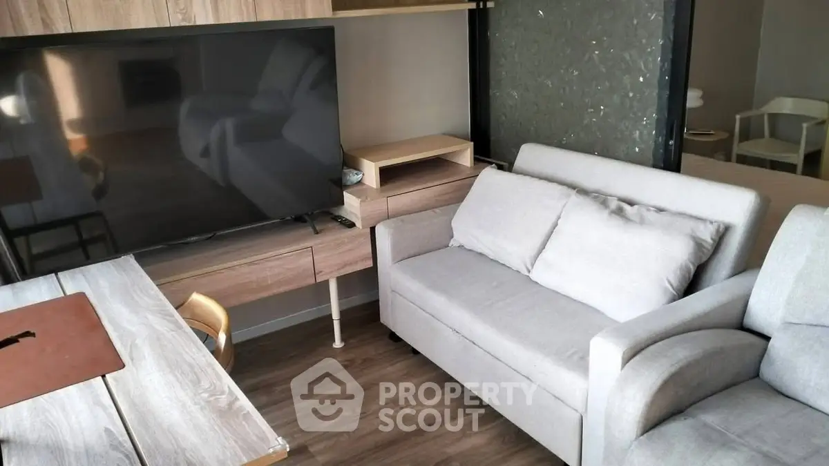 Modern living room with sleek furniture and large TV, perfect for relaxation.