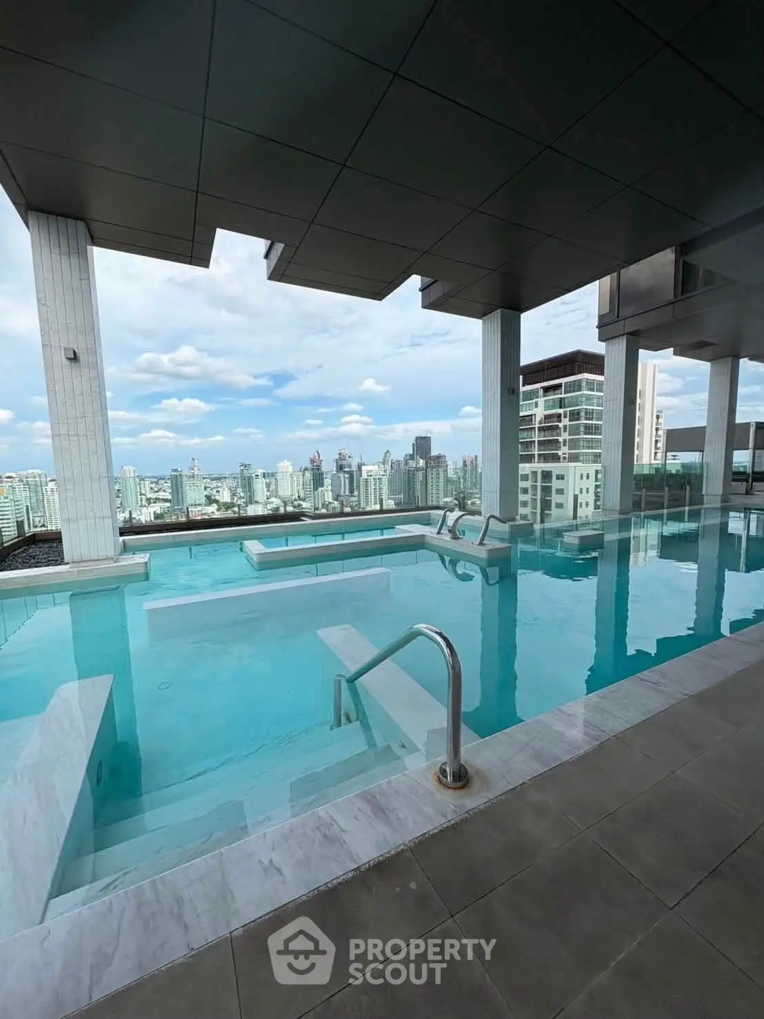 Luxurious rooftop pool with stunning city skyline views in modern high-rise building.