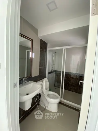 Modern bathroom with sleek design, featuring a glass shower enclosure and elegant fixtures.