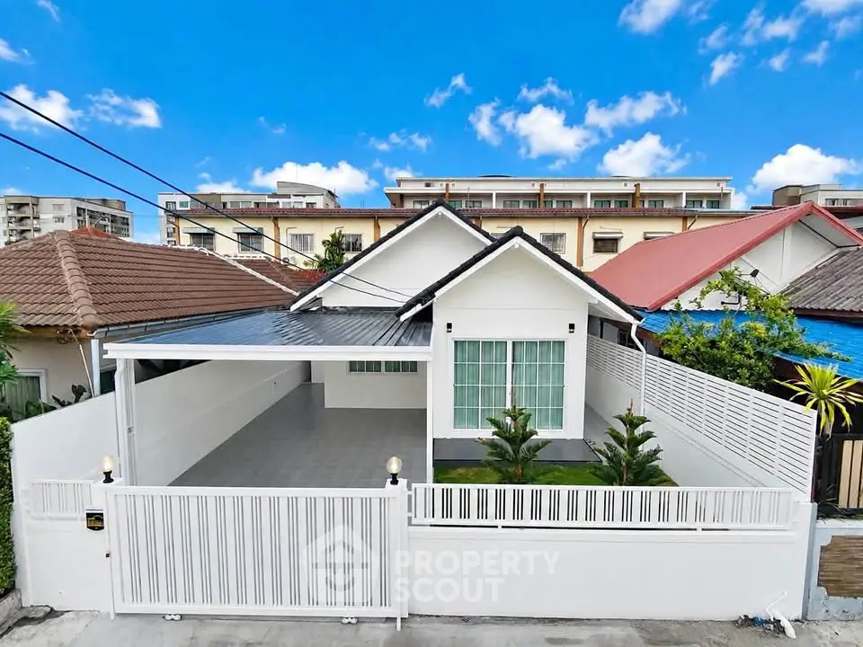 Charming single-story white house with modern design and spacious driveway in a serene neighborhood.