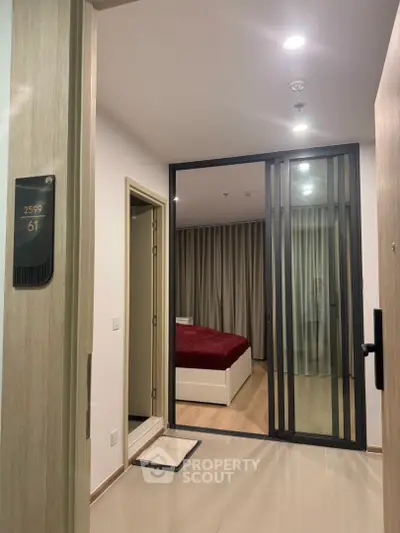 Modern apartment entrance with view into stylish bedroom