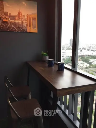 Cozy corner with a high table and chairs overlooking a stunning city view, perfect for morning coffee.