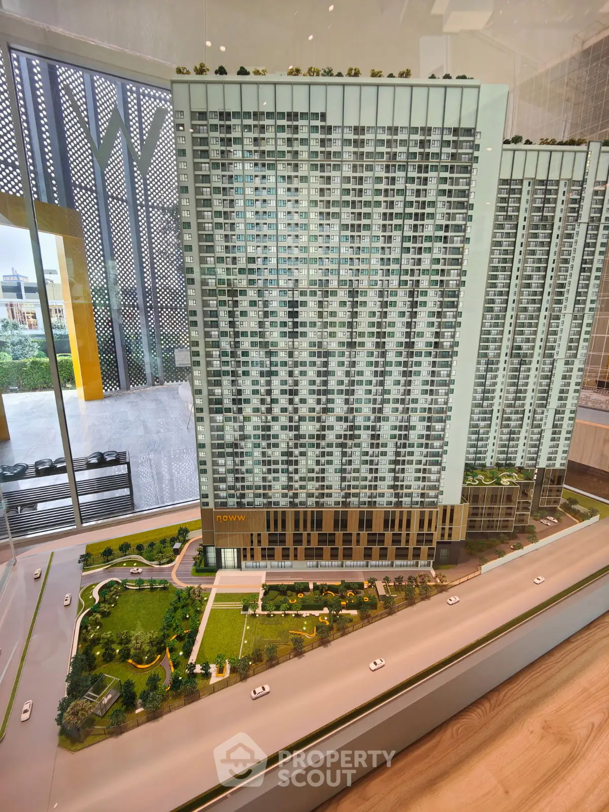 Stunning architectural model of a modern high-rise building with lush landscaping and urban design.