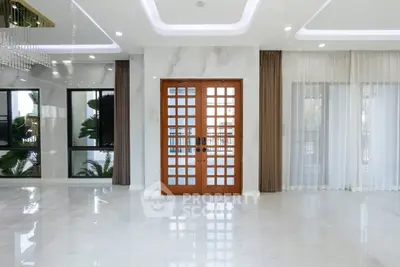 Luxurious modern living room with elegant marble flooring and stylish wooden double doors.