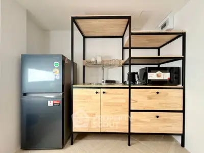 Modern kitchen with sleek fridge and stylish wooden cabinetry, perfect for contemporary living.