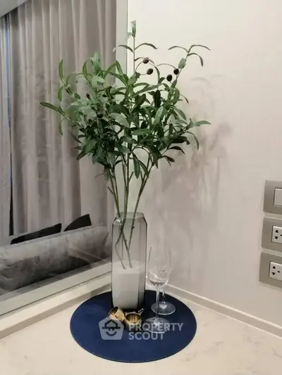 Elegant interior decor with tall vase and wine glasses on marble countertop