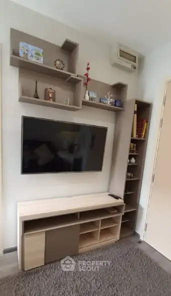 Modern living room with stylish TV unit and shelving, perfect for cozy entertainment.