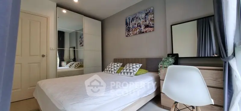 Modern bedroom with stylish decor and large mirror wardrobe