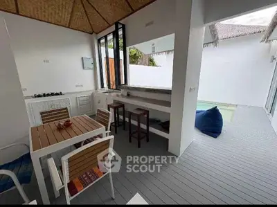 Charming open-layout kitchen with outdoor seating and pool view, perfect for modern living.