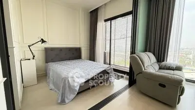 Modern bedroom with panoramic city view and cozy seating area