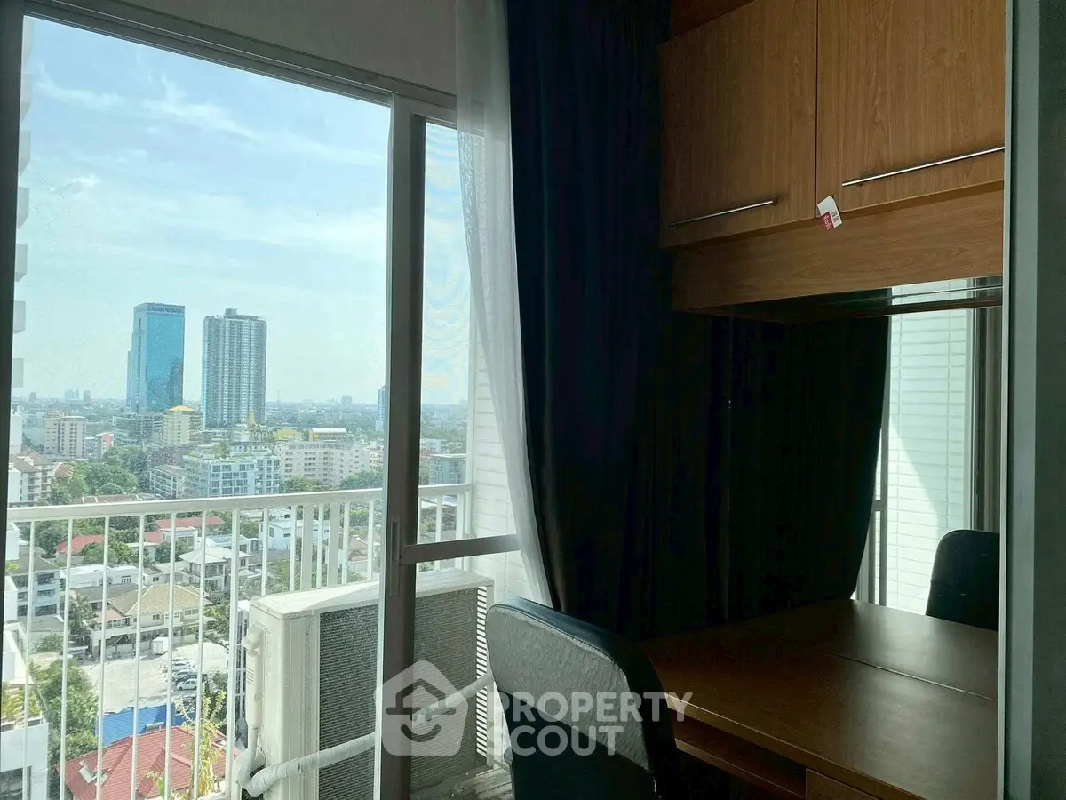 High-rise apartment with city view and cozy study area, perfect for urban living.