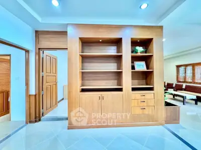 Spacious living room with elegant wooden built-in shelves and modern lighting