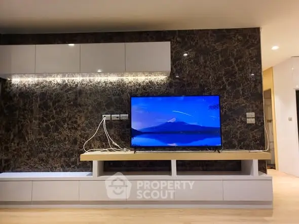 Modern living room with sleek TV setup and elegant marble accent wall.