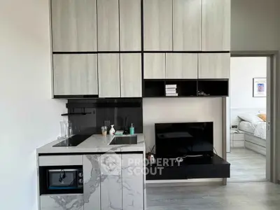 Modern compact kitchen with sleek cabinetry and integrated appliances in stylish apartment.