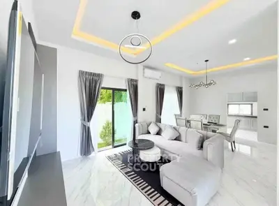 Luxurious modern living room with elegant decor and open dining area, featuring sleek furniture and ambient lighting.