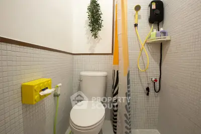 Modern bathroom with shower and toilet, featuring stylish tile design and vibrant accents.