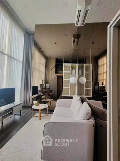 Luxurious modern living room with high ceilings and elegant decor in a stylish apartment.
