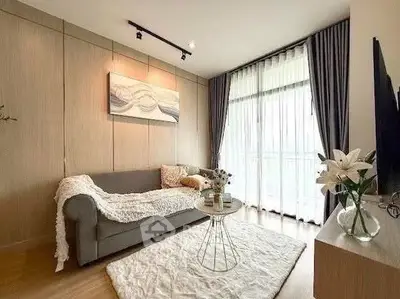 Stylish living room with cozy sofa, elegant decor, and large window for natural light.
