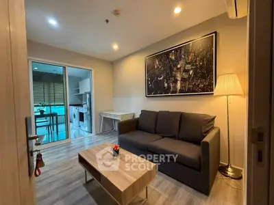 Modern living room with stylish decor and open kitchen view, featuring cozy sofa and elegant lighting.