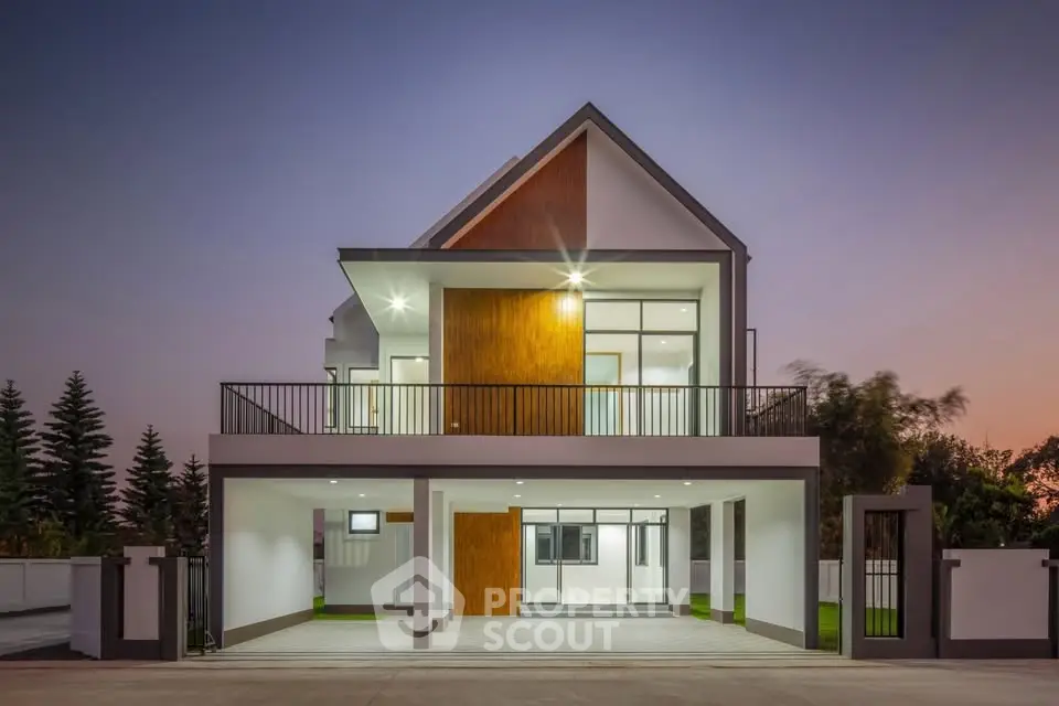 Modern two-story house with sleek design and spacious balcony at sunset.