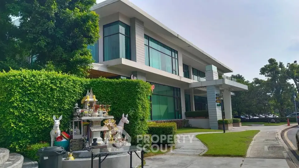 Modern commercial building with lush greenery and sidewalk view