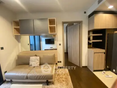Modern living room with sleek furniture and open kitchen layout in a stylish apartment.