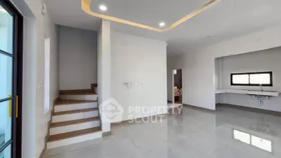 Modern interior with sleek staircase and open layout kitchen in a bright, spacious home.