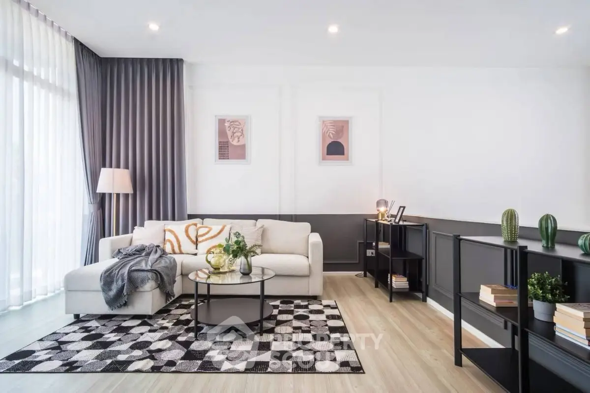 Modern living room with stylish decor, large windows, and cozy seating area.
