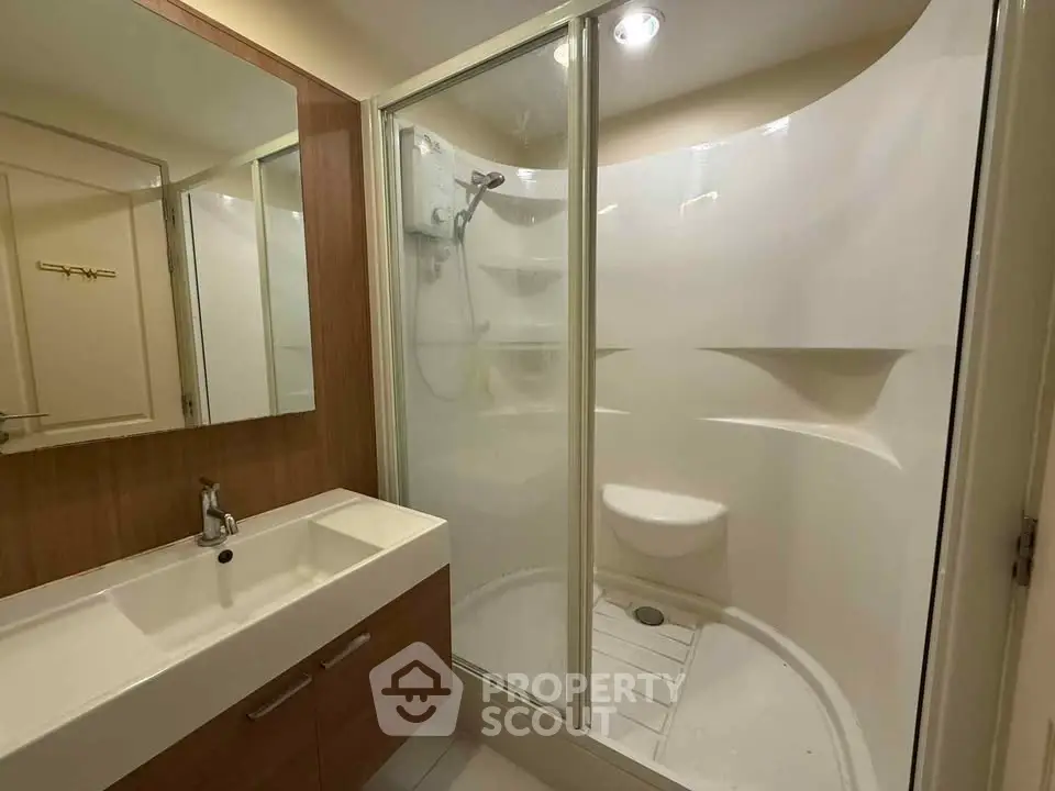 Modern bathroom with sleek shower and stylish vanity in contemporary apartment.