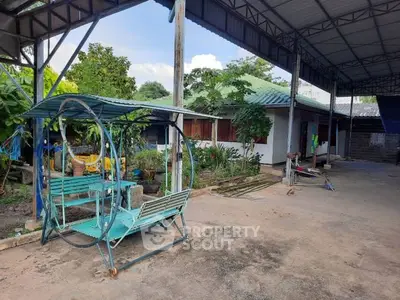 Charming outdoor space with covered seating area and lush greenery, perfect for relaxation and gatherings.