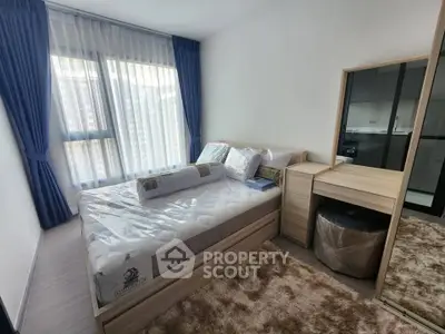 Modern bedroom with large window and stylish furniture in a contemporary apartment.